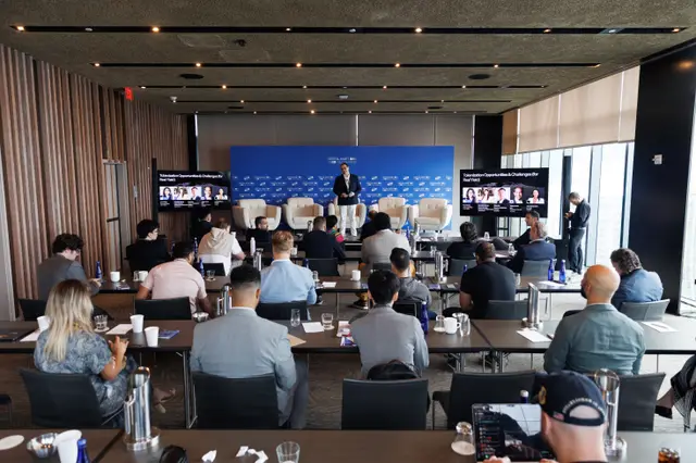 Wide view of the main room with the stage panel and seated audience