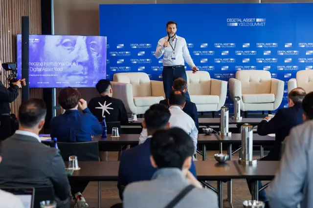A speaker addressing the room beside the opening slide